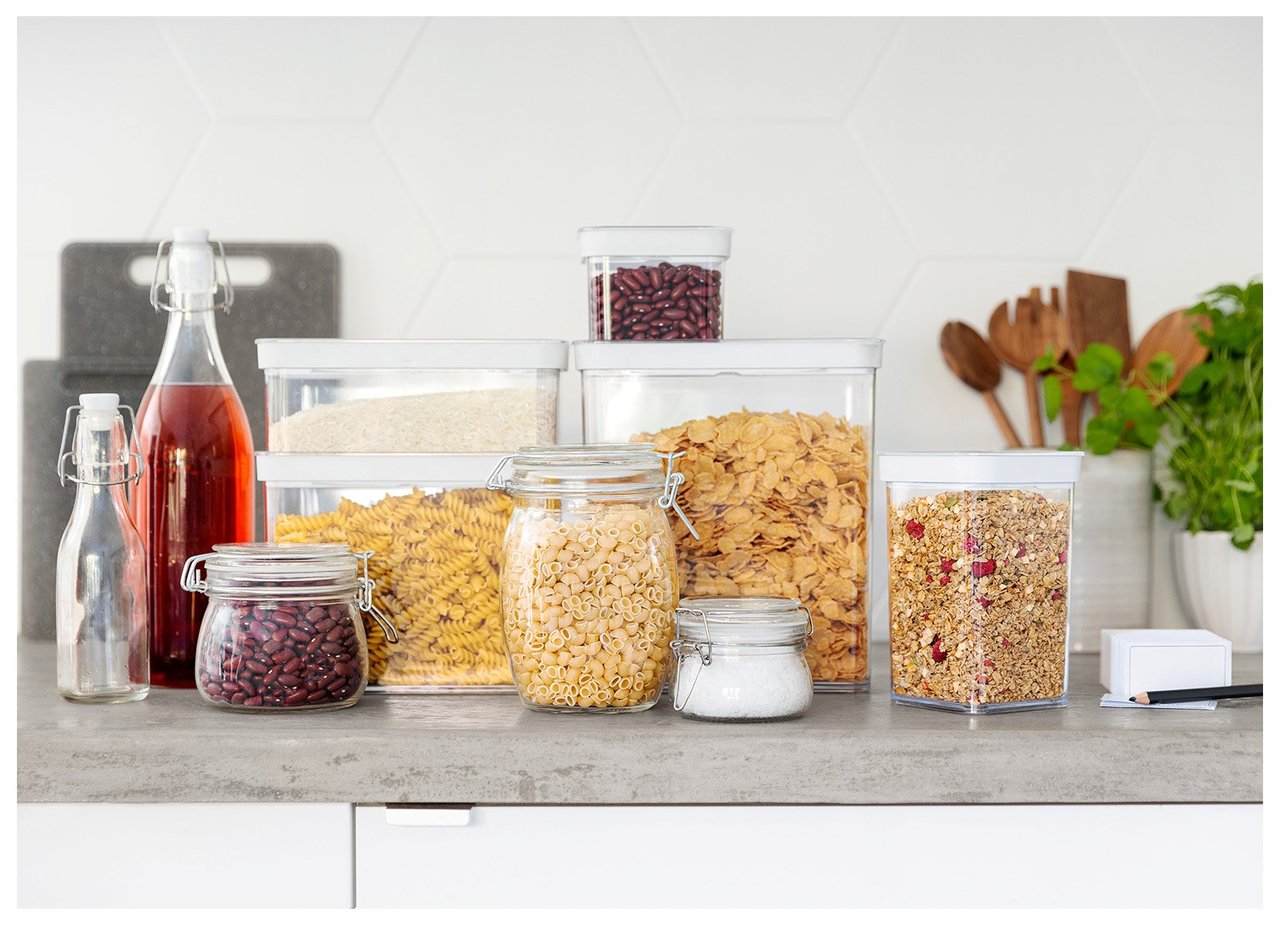 Köksbänk med förvaringsburkar fyllda med torrvaror i ett organiserat kök.
