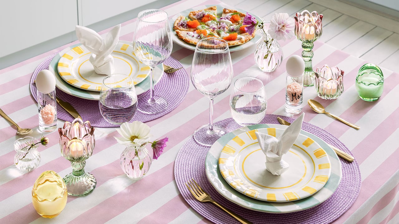 Bord med påskdukning i rosa, lila och gult.