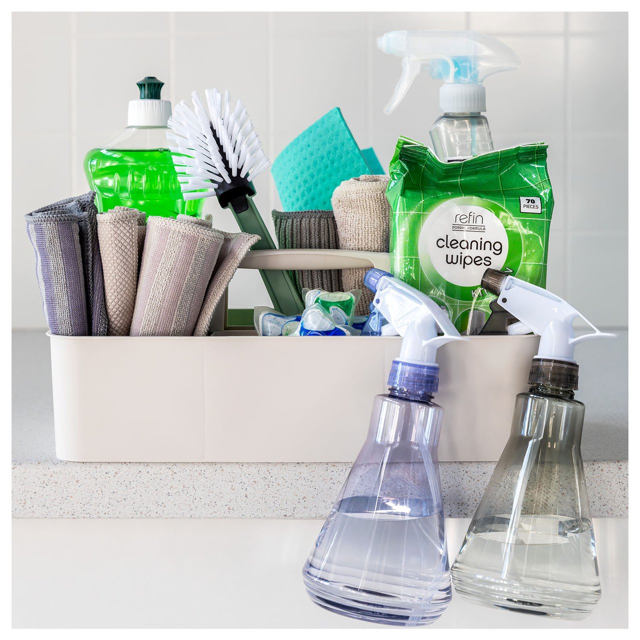 Beige Kunststoffbox mit Griffen, die Mikrofasertücher, ein Geschirrtuch, Sprühflaschen und Reinigungsmittel enthält.