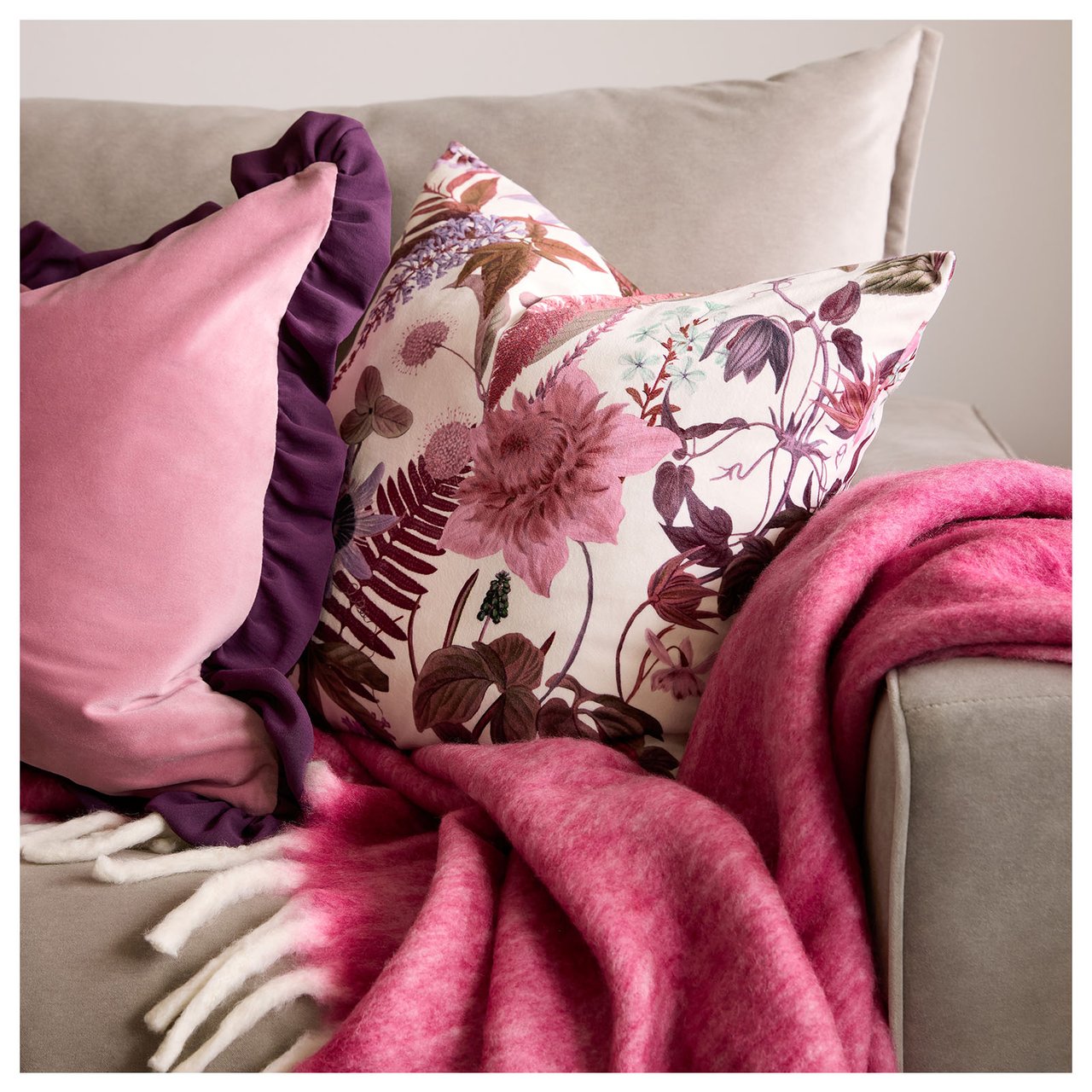 Sofaecke mit Kissen und Decke in Rosatönen.