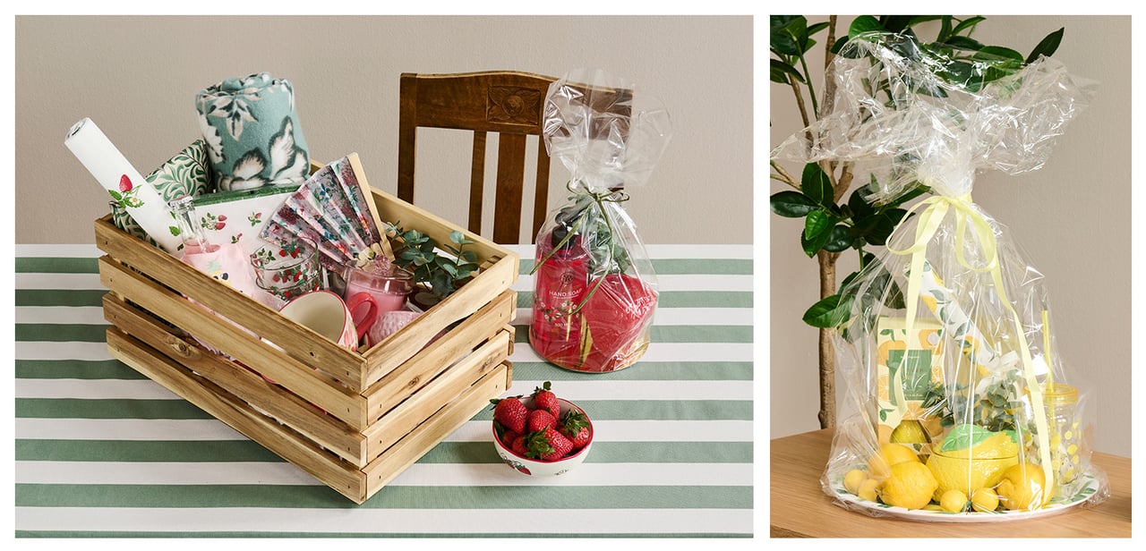 Puulaatikko, jossa torkkupeitto, servettejä, mukeja, pöytäliina ja viuhka. Keltaiset sitruunakuosiset sisustustuotteet sellofaaniin käärittynä.