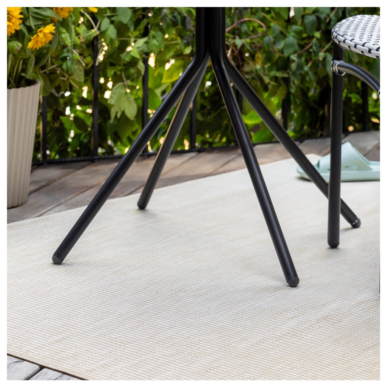 Beige teppe under svart bord på en balkong.