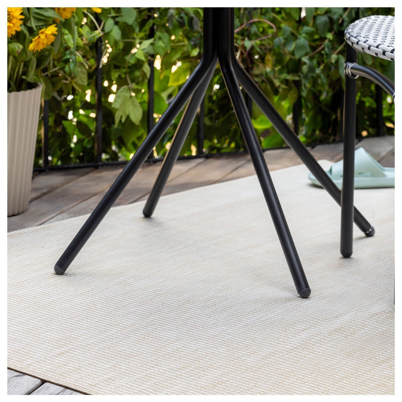 Beige teppe under svart bord på en balkong.