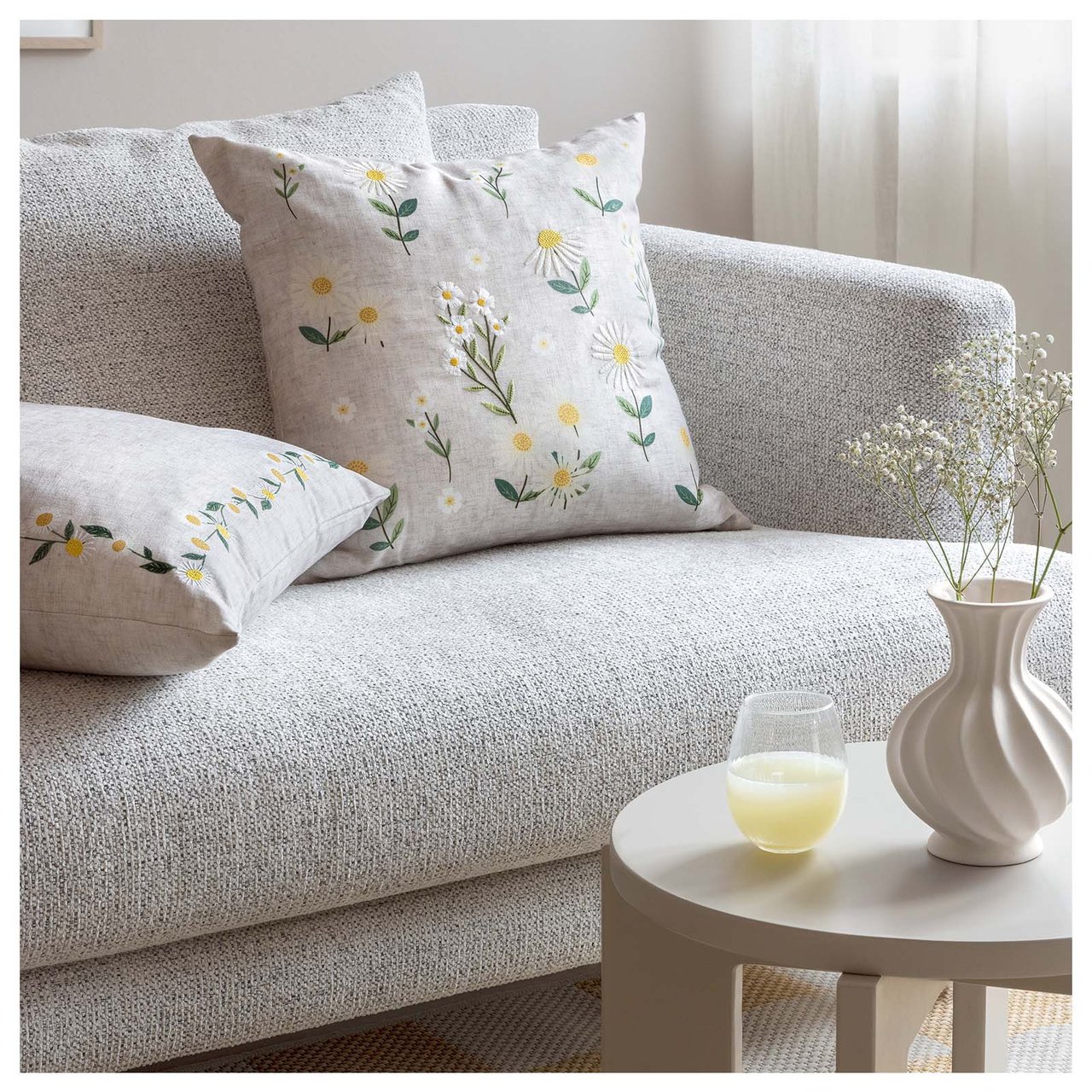 Soffa med kuddar i olika blommiga mönster.