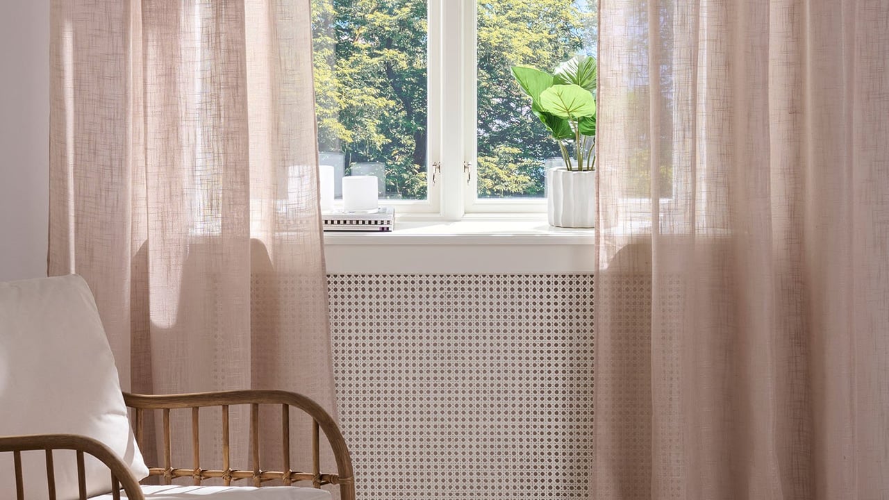 Beige, tynne gardiner i en stue.