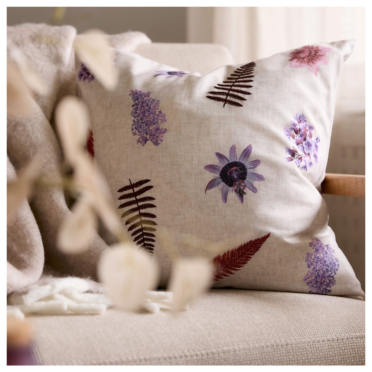 Auf dem Sofa liegt ein Kissen mit gesticktem Muster.