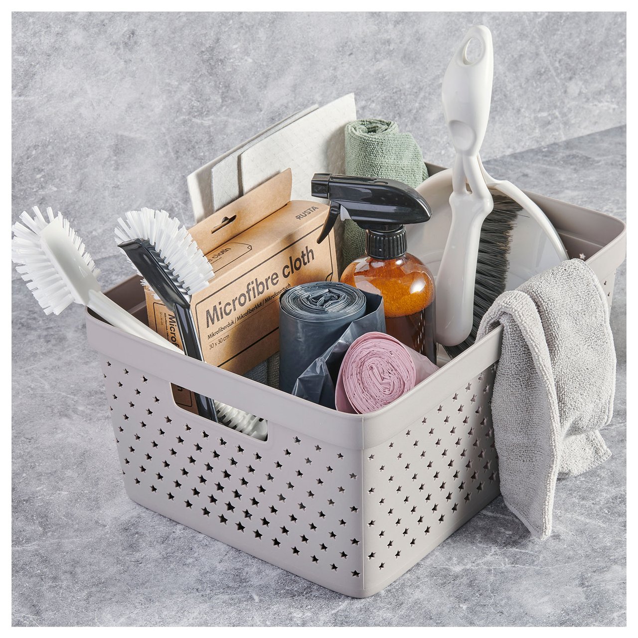 Aufbewahrungskorb aus Kunststoff, gefüllt mit Reinigungsprodukten, Bürsten, Putztüchern und Reinigungsmitteln im Badezimmer.