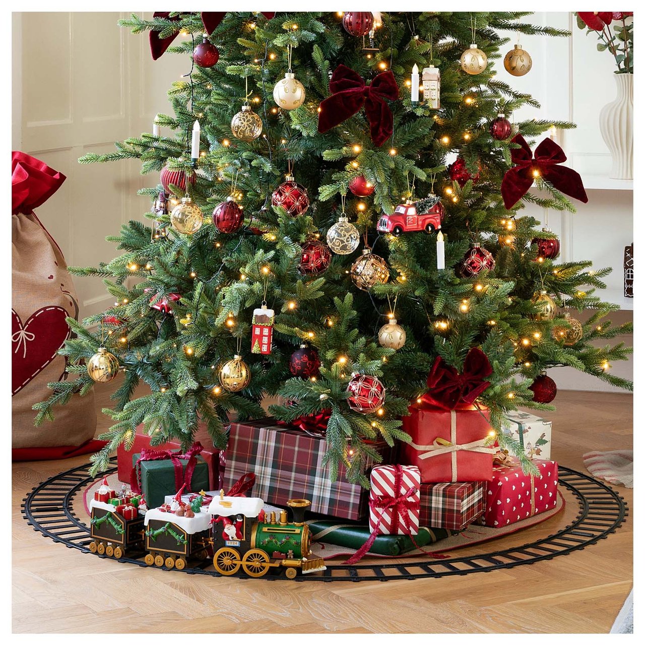 Eine Eisenbahn fährt um einen Kunstbaum mit Geschenken.