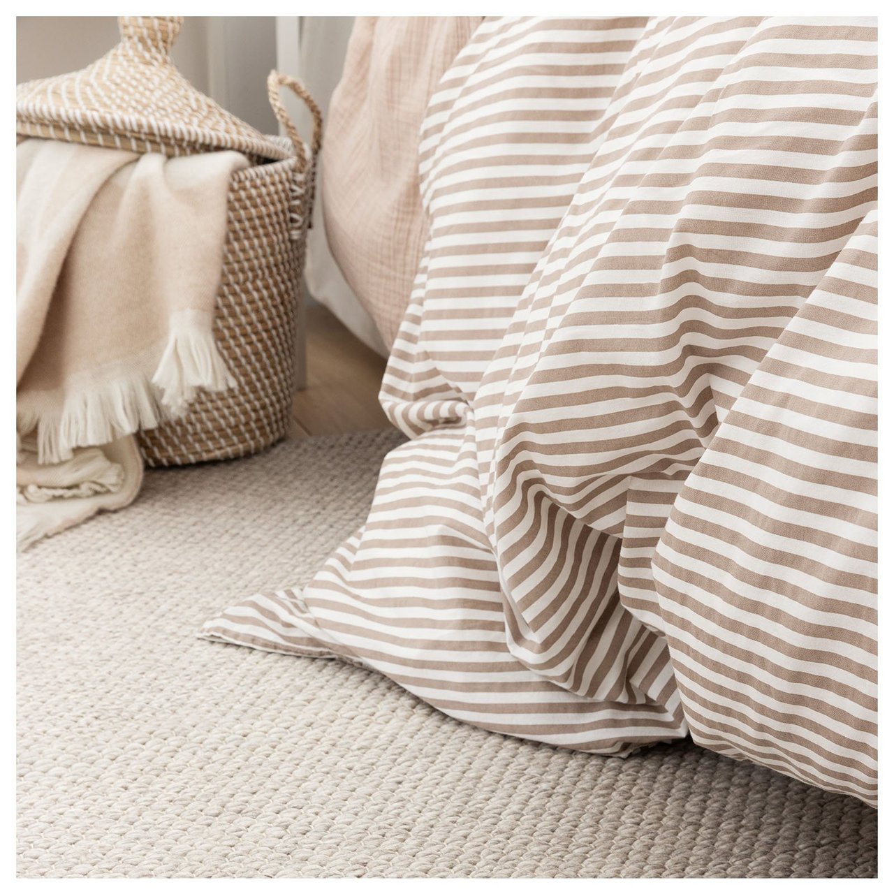 Beigefarbener Wollteppich unter dem Bett.