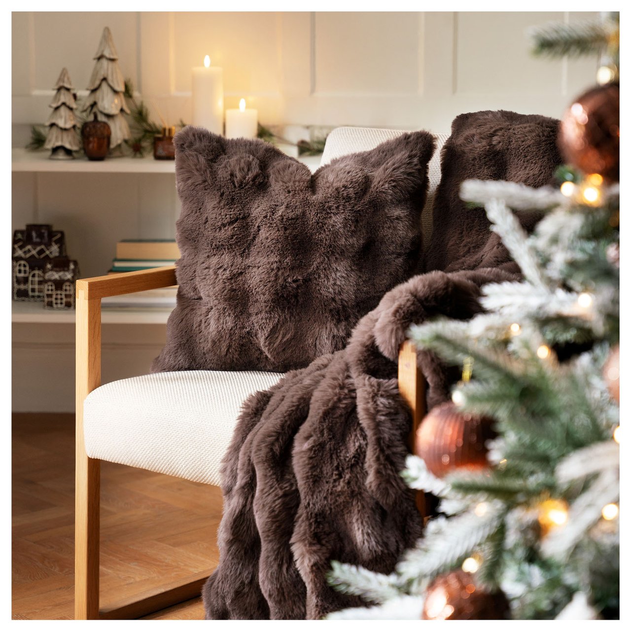 Joulukoristeltu nurkka pehmeillä tekstiileillä, kynttilöillä ja koristeilla luo lämpimän ja kodikkaan tunnelman.