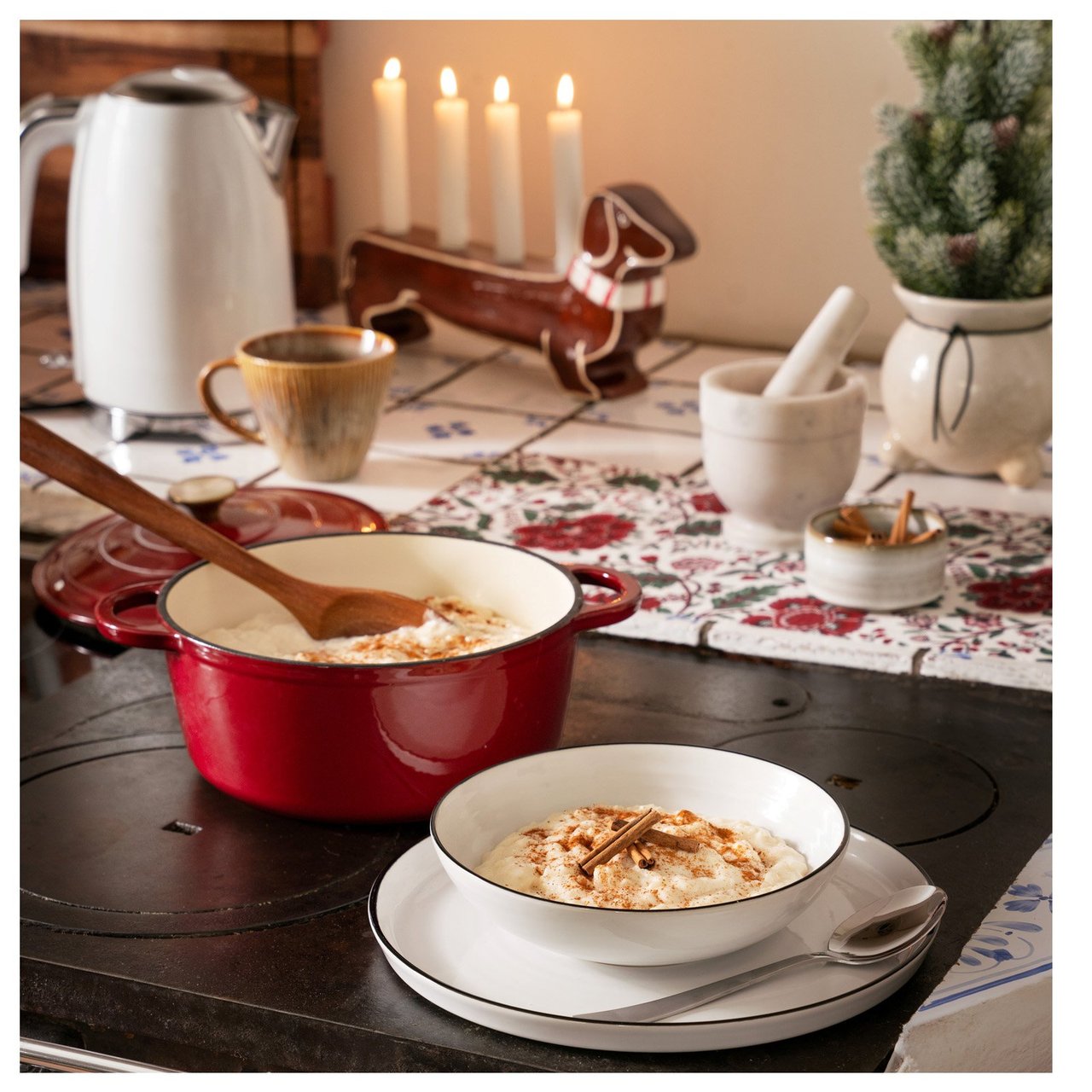 Roter Topf und Teller Milchreis auf altem Holzofen.