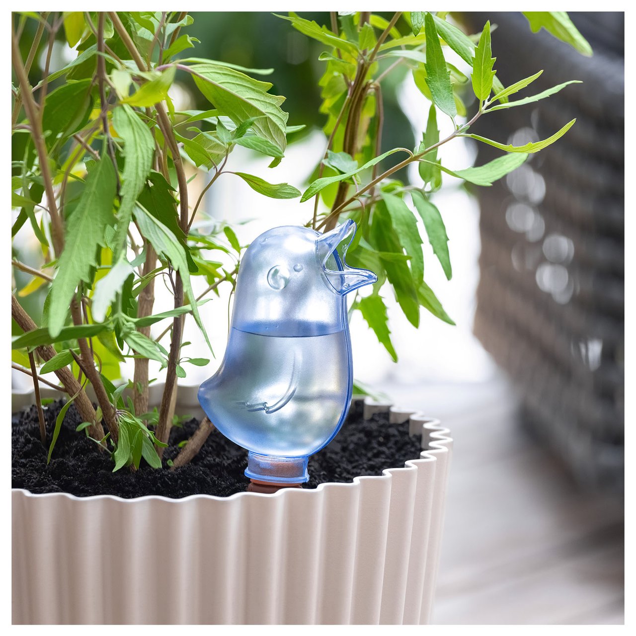 Ferievanner i form av en blå fugl står i en potte.