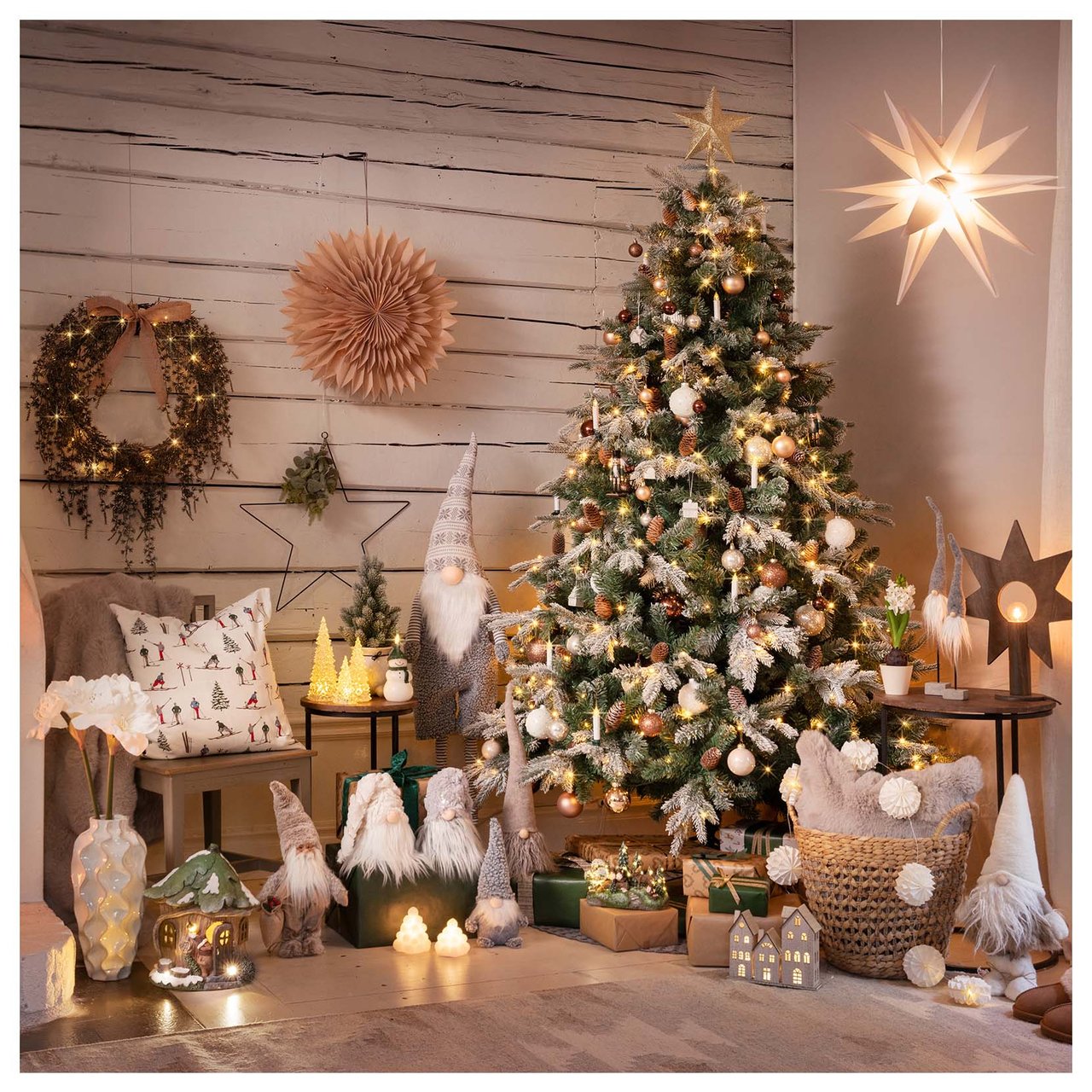 Ein Weihnachtsbaum mit Lichtern und Schmuck, umgeben von Weihnachtsgeschenken und hängenden Weihnachtssternen.