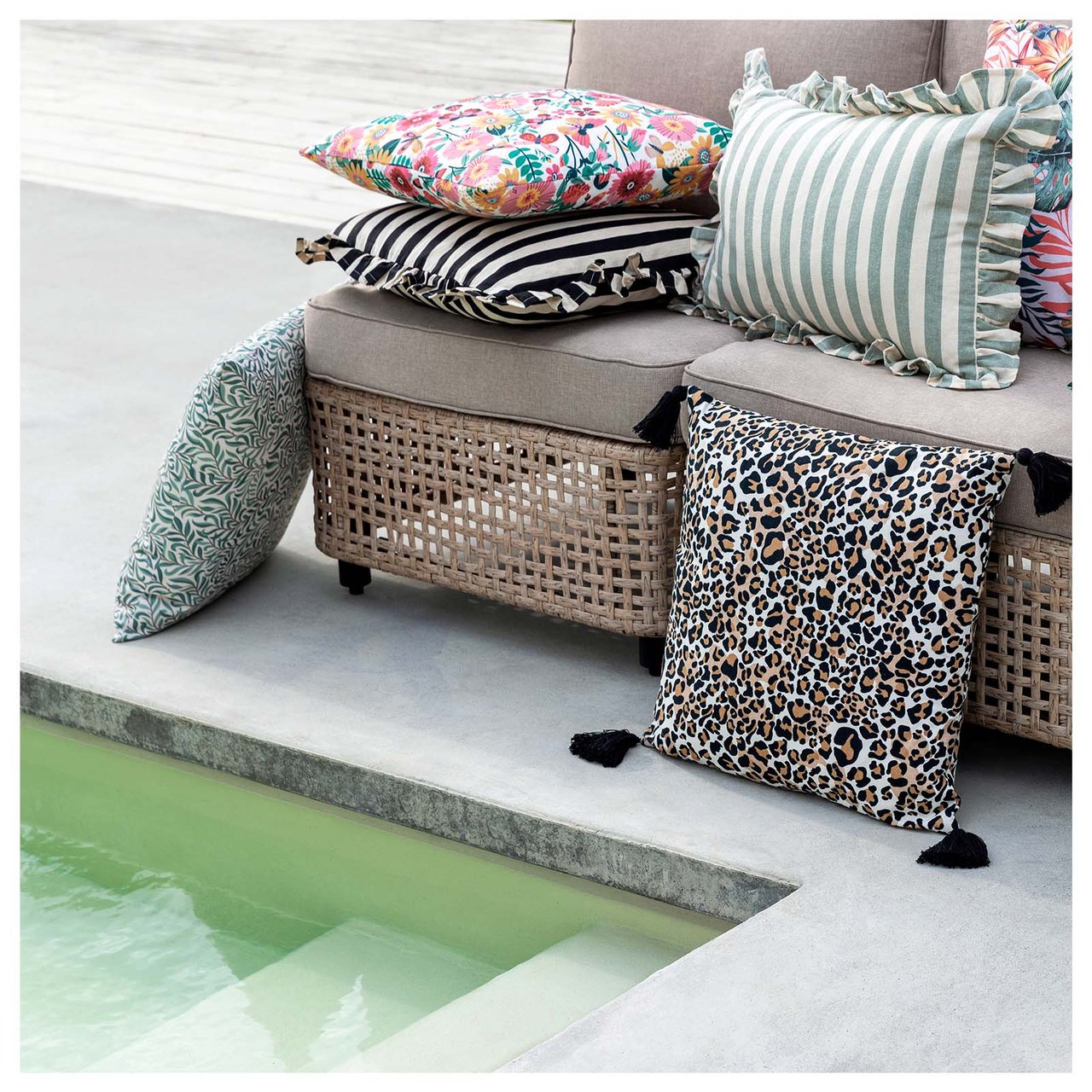 En sofagruppe i stål med grå puter på et teppe med sebrastriper.