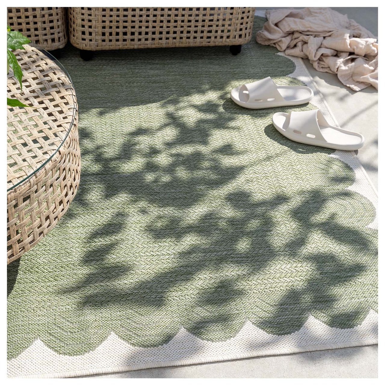 Grønt teppe under beige sofabord på en uteplass.