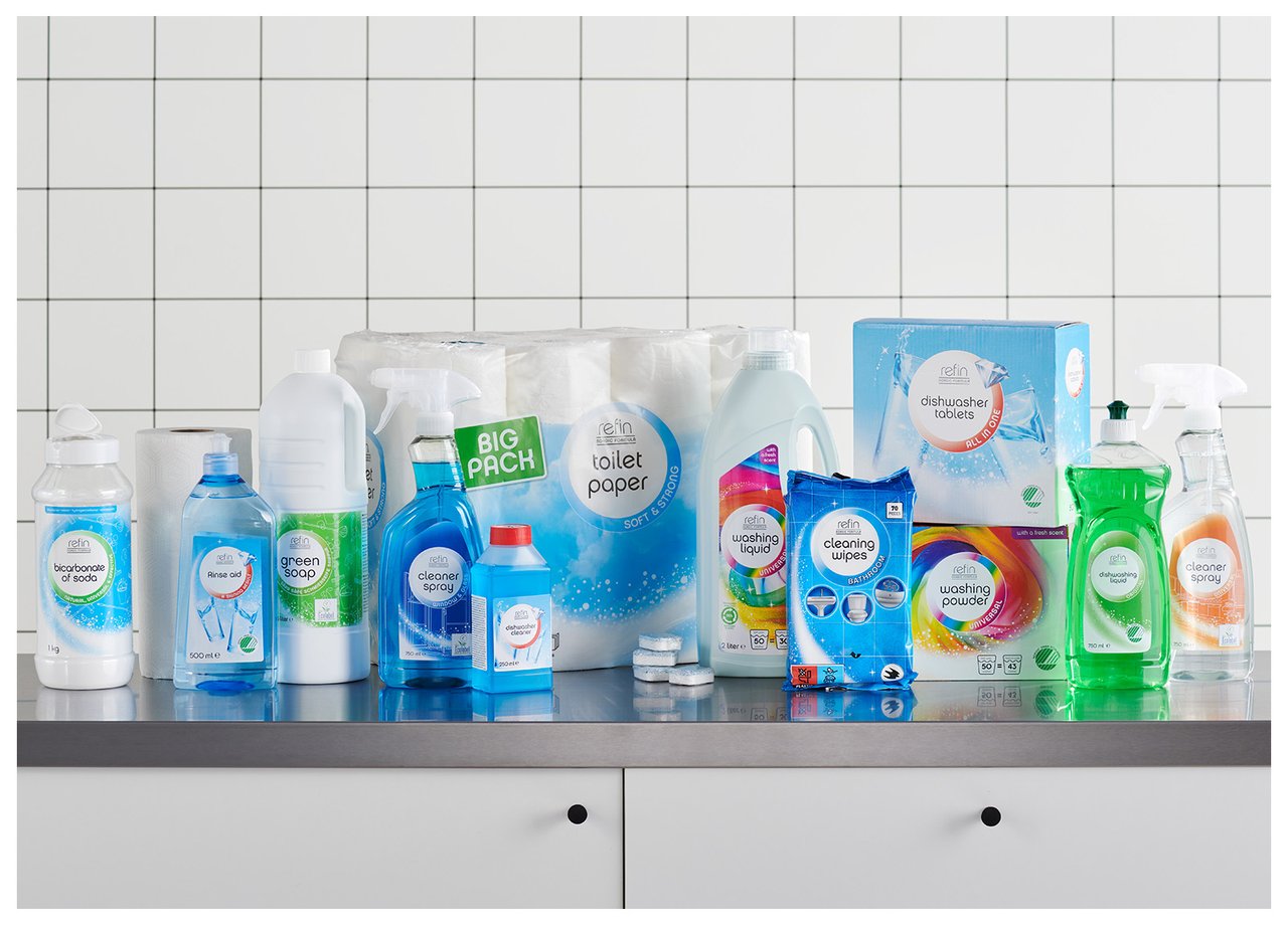 Auf einer Edelstahlablage stehen zahlreiche Reinigungsmittel wie Seife, Reinigungsspray, Papier und Tücher.