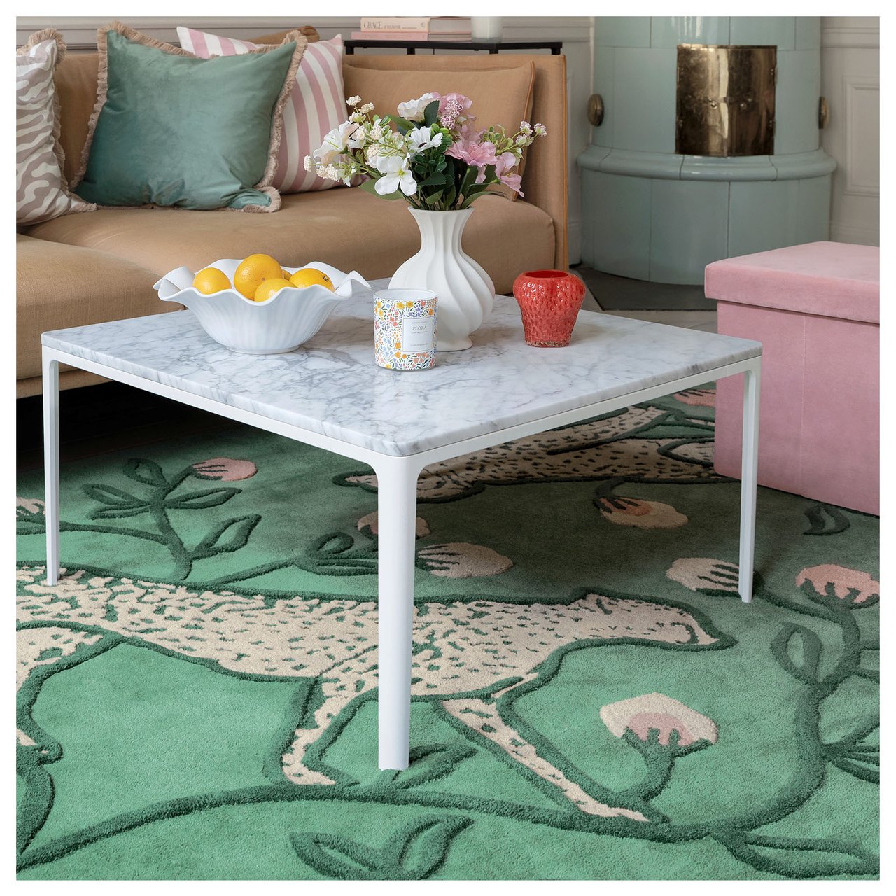 Stue med pastellfarget innredning og grønt teppe med to store geparder.