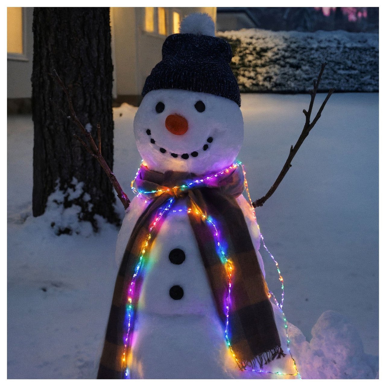 Snögubbe med färgglad ljusslinga.