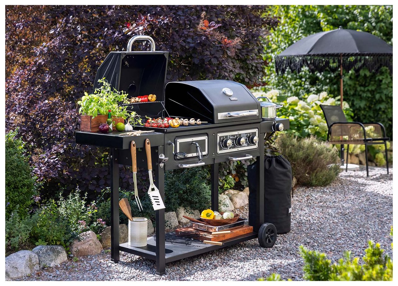 Kombinierter Kohle- und Gasgrill auf einem Kiesweg im Garten.