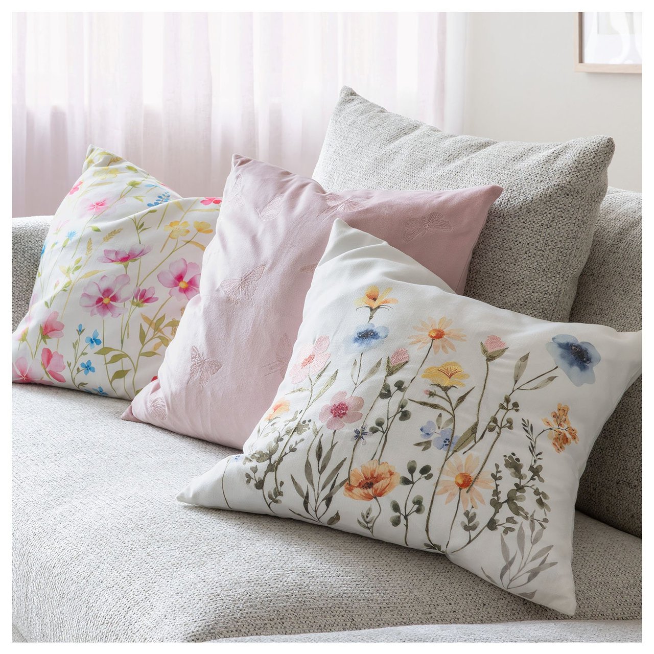 Soffa med kuddar i olika blommiga mönster.