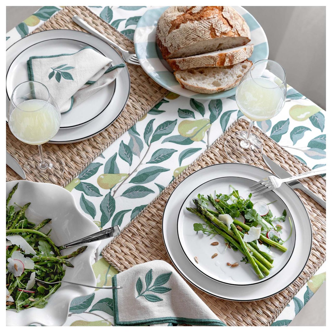 Dukat bord med grön, päronmönstrad duk, tabletter i sjögräs och tygservetter med broderade grönalöv.