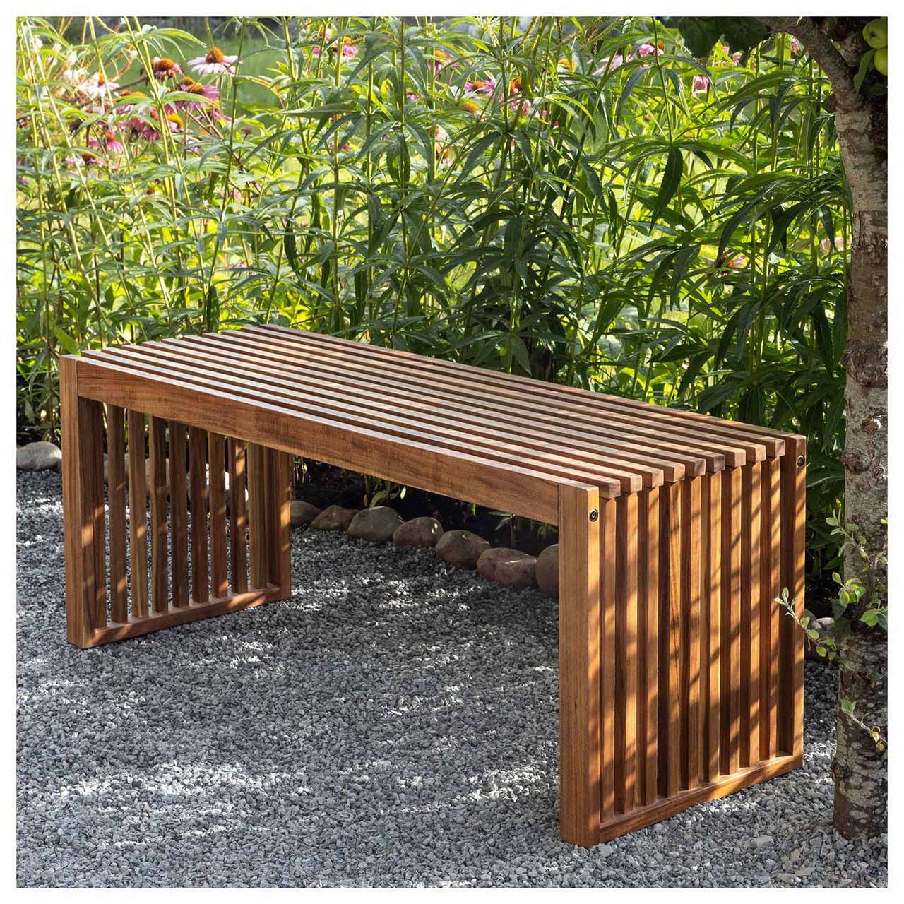 En brun trebenk står ved et tre på en grusgang.