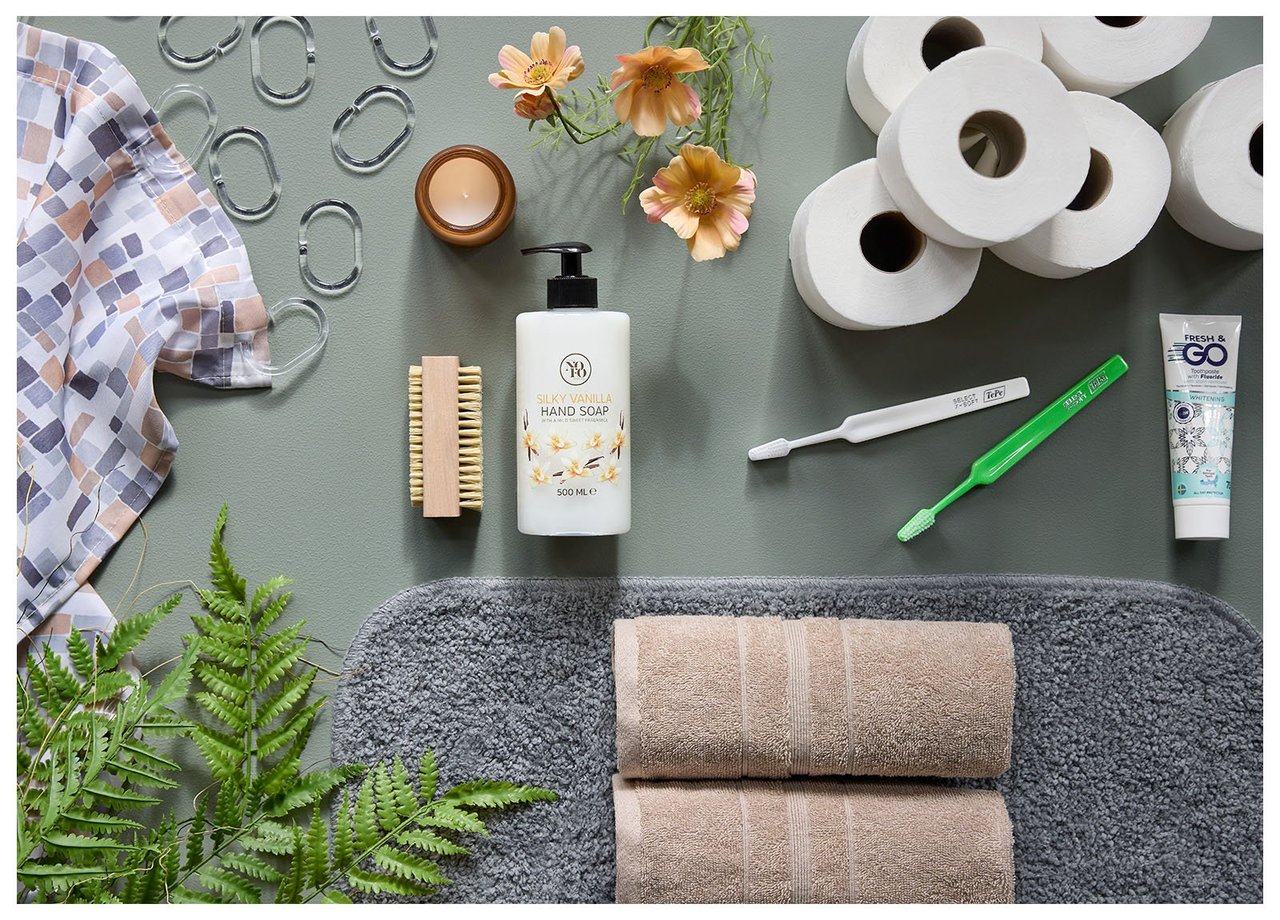 Badrumsprodukter som handdukar, badrumsmatta, toapapper, tandborstar, tvål och duschdraperi.