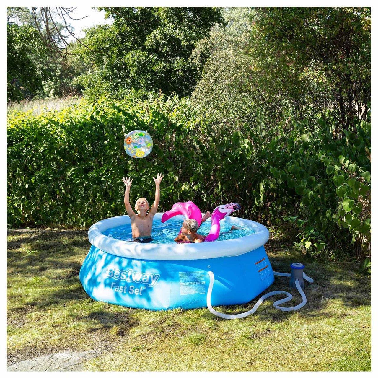 Zwei Kinder baden mit Wasserspielzeug in einem aufblasbaren Pool.