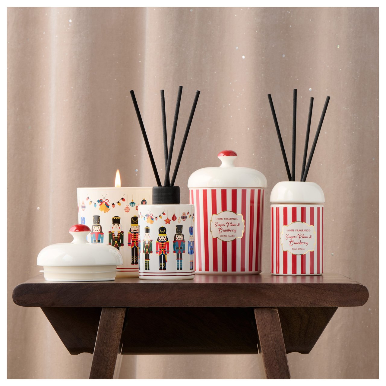 Duftkerzen und Diffusoren auf Holztisch, mit Nussknacker-Motiv und rot-weißem Streifenmuster.