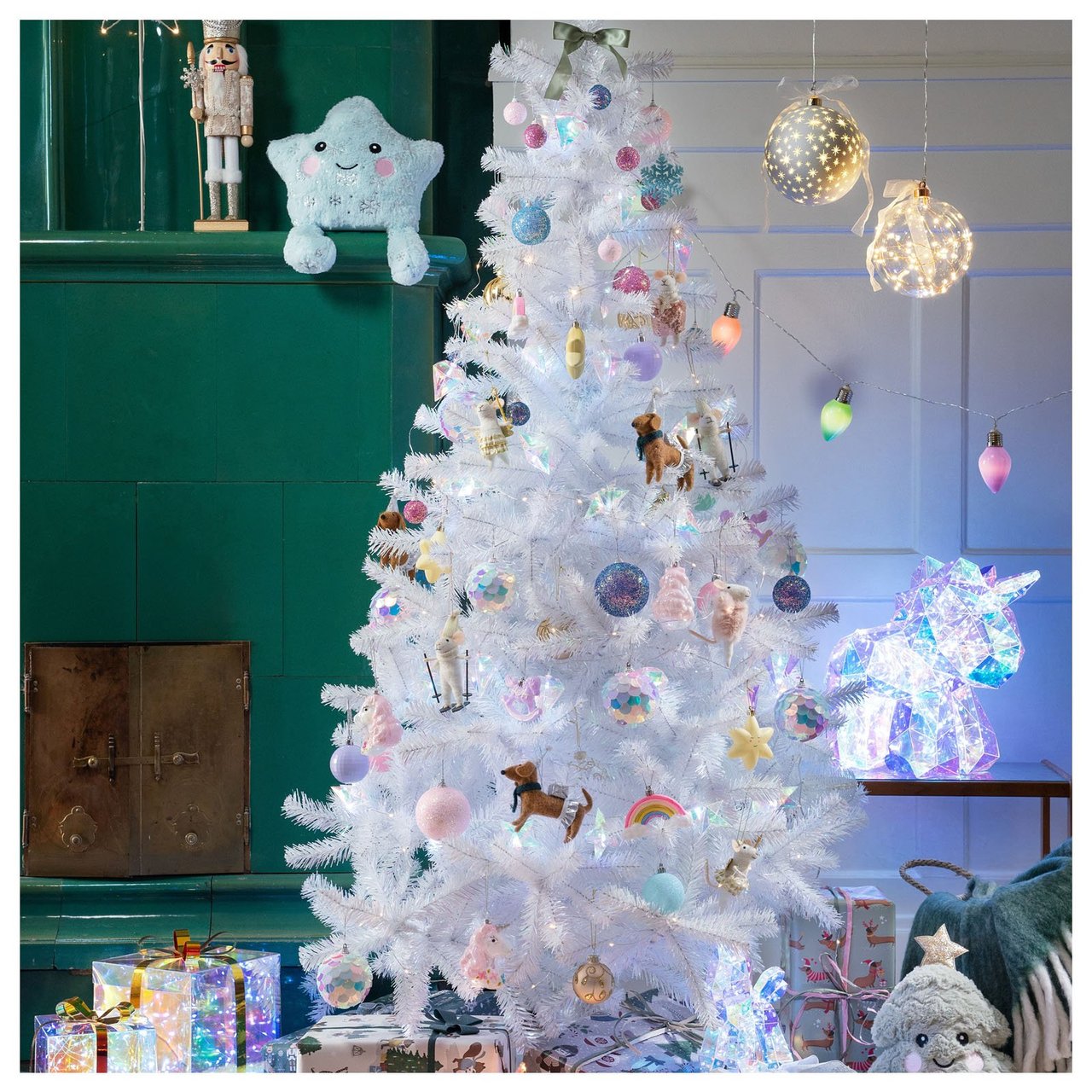 Weißer Kunstbaum mit pastellfarbenem Schmuck und Geschenken darunter.