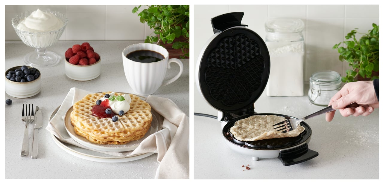 Eine Küche mit mehreren Waffeleisen, frisch gebackenen Waffeln und Beilagen wie Marmelade und Sahne.