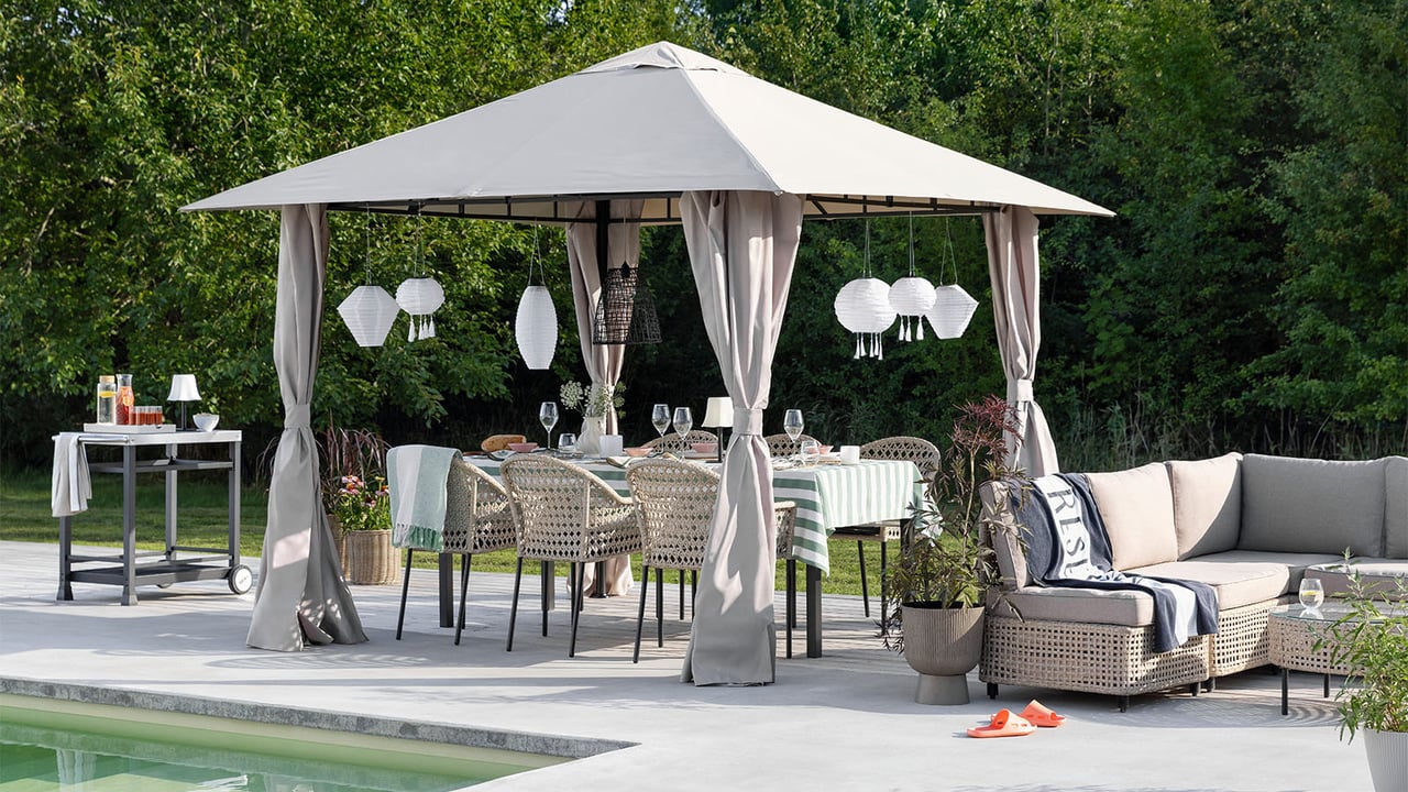 Bord och stolar i en paviljong med intill en pool.