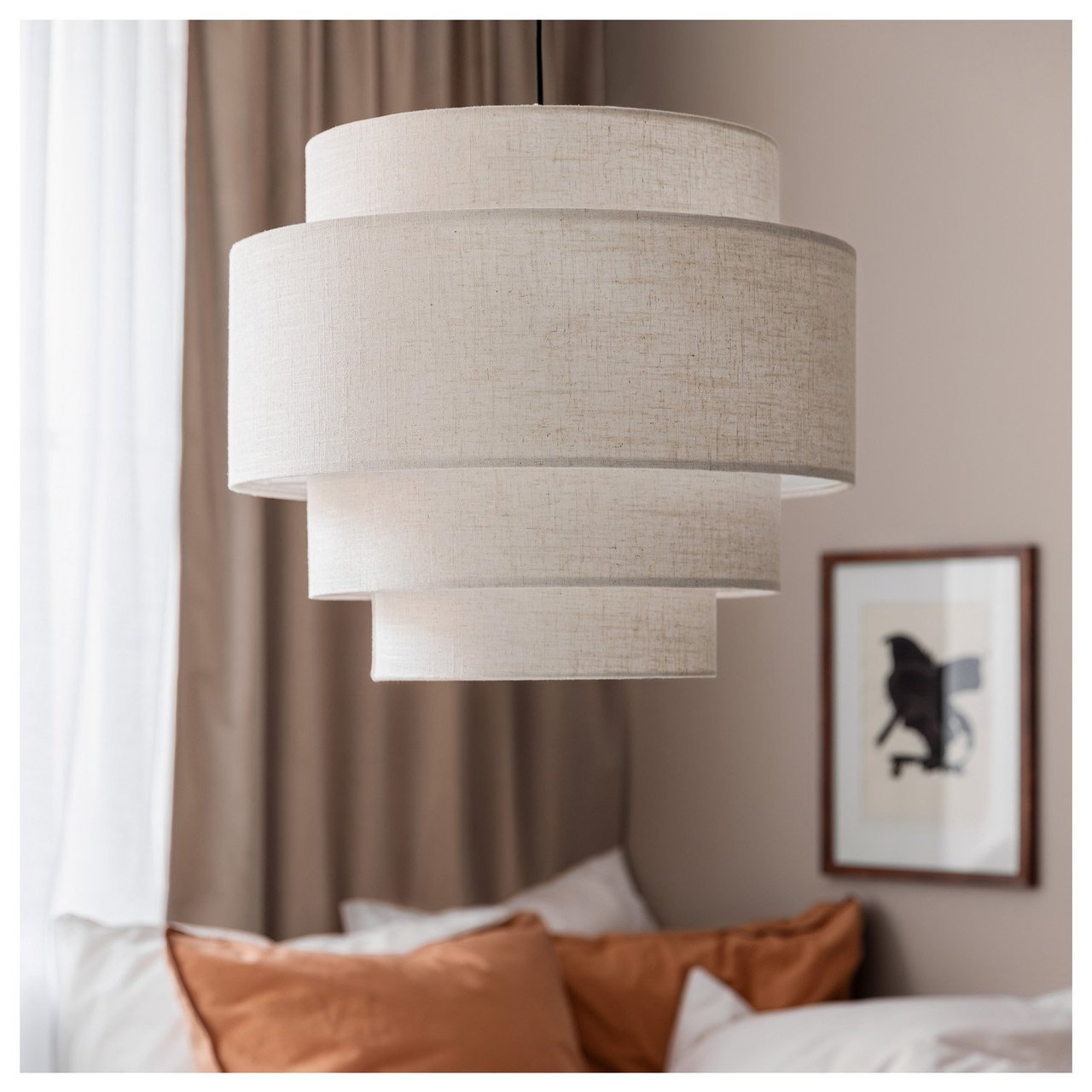 Stoffbezogene Deckenlampe in mehrschichtigem Design über einem gemachten Bett in einem Schlafzimmer.