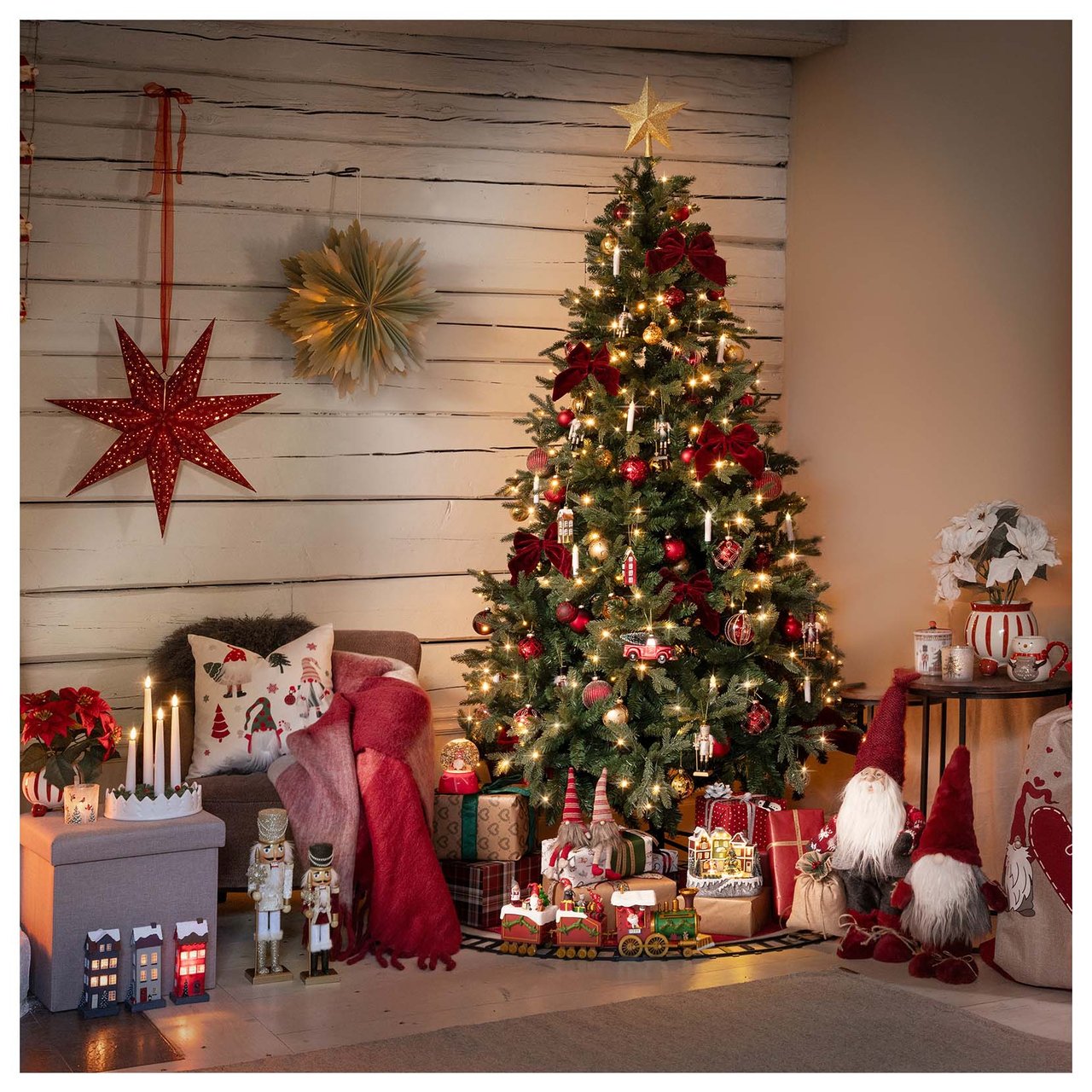 Weihnachtsbaum mit Christbaumkugeln und Kerzen, umgeben von Weihnachtsgeschenken, Weihnachtsmännern und gemütlicher Dekoration.