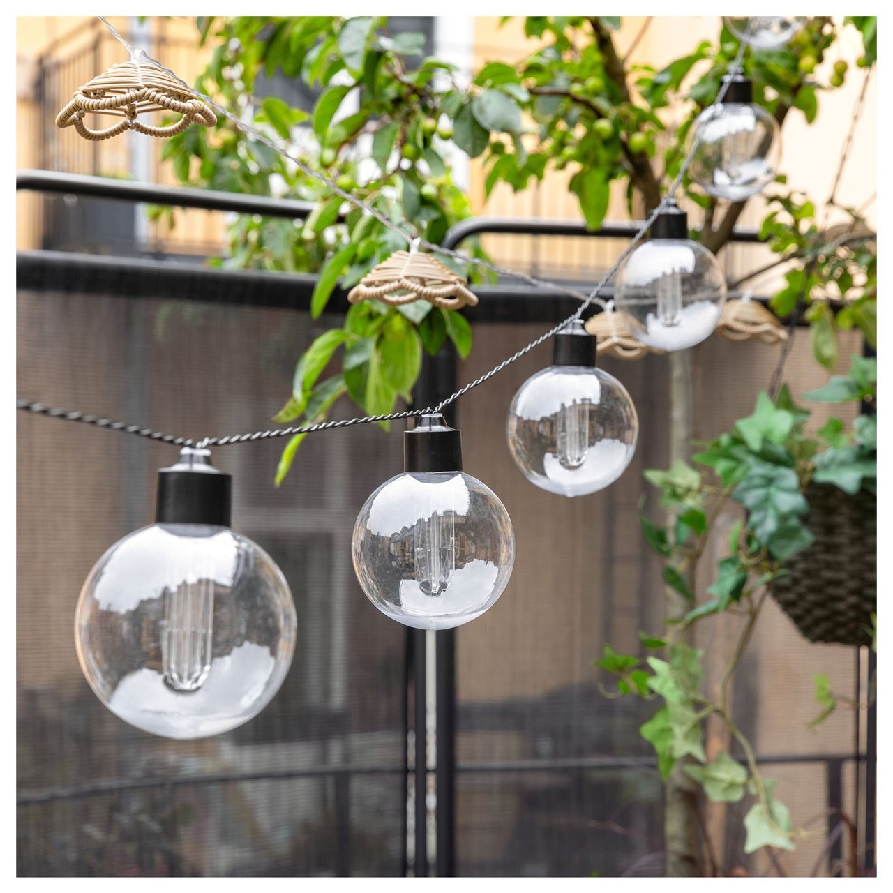 Svart lysslynge med gjennomsiktige lyspærer på en balkong.