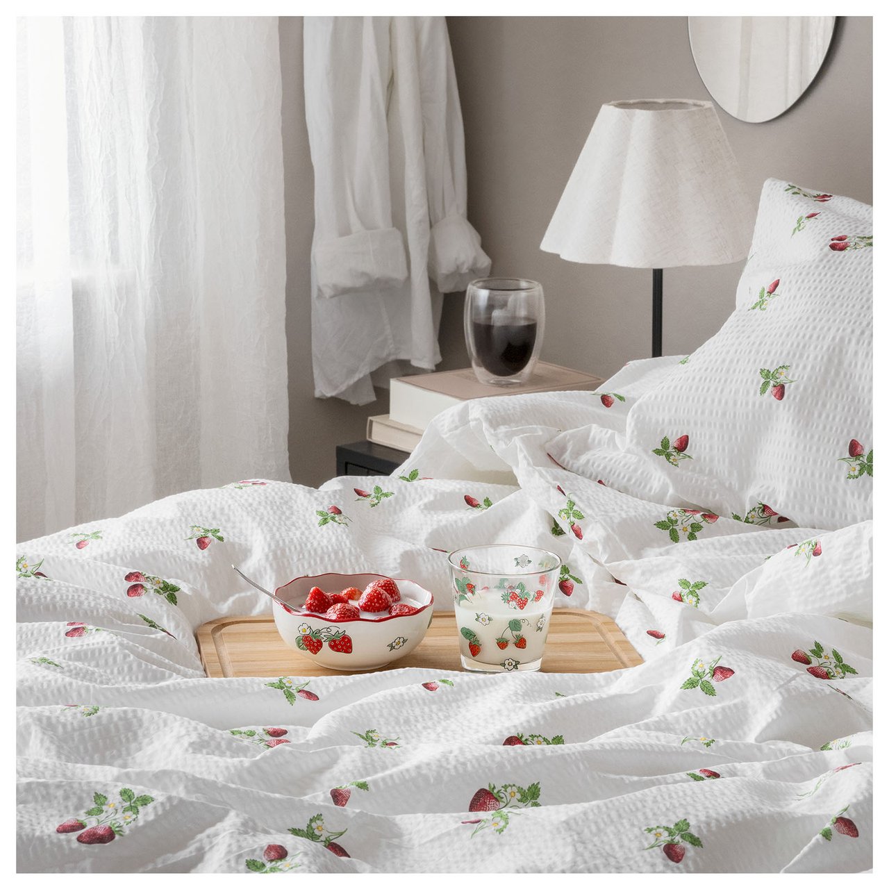 Säng med jordgubbsmönstrade sängkläder.