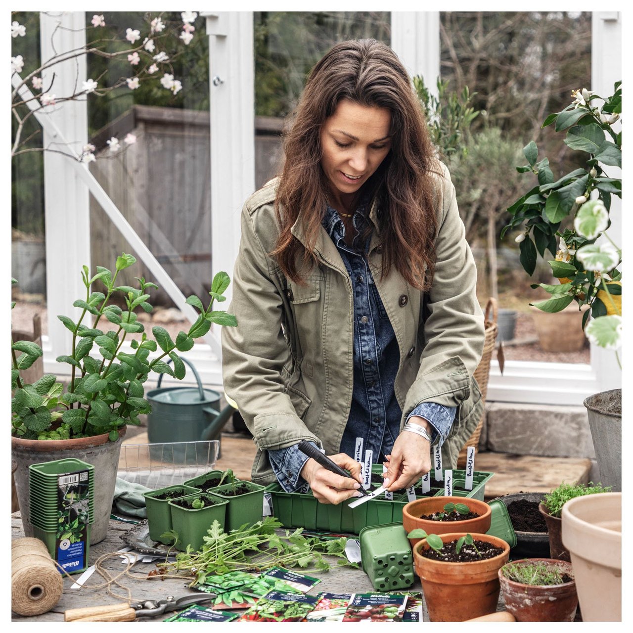 Influenseren Sofia Björk skriver på plastetiketter som stikkes ned i plastpotter.