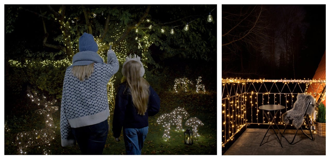 Två personer i en trädgård beundrar dekorationer med ljus och träd med ljusslingor. Balkong med ljusslingor runt räcket.