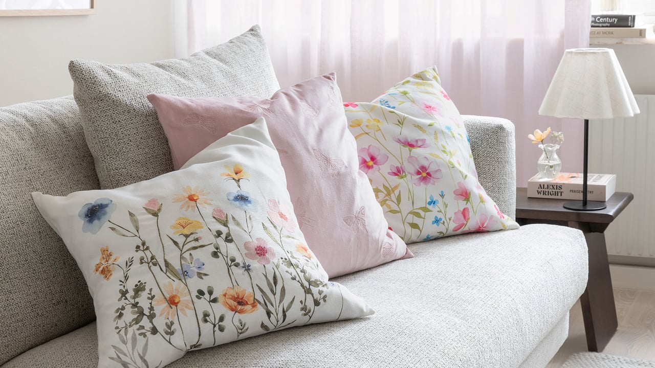 Blommiga kuddar i en soffa.