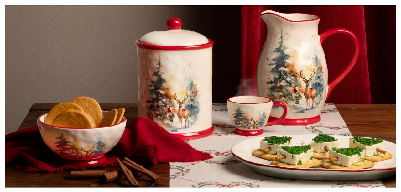 Kopper og serveringsskåler er satt frem med småkaker og snitter på et julepyntet bord.