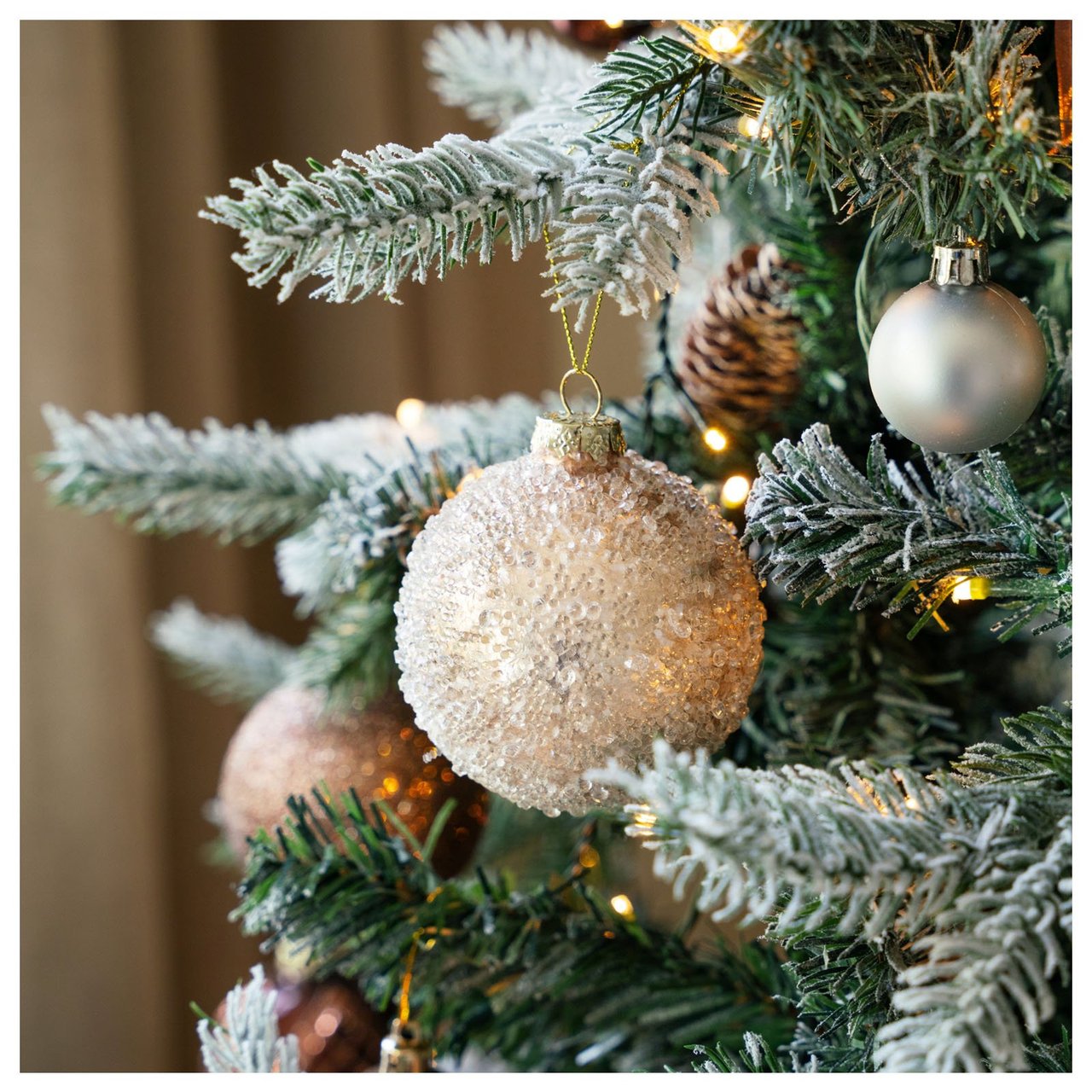 Kleine integrierte Lichter und Weihnachtskugeln in einem künstlichen Weihnachtsbaum.