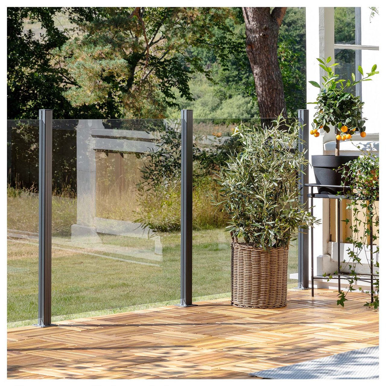 Del av altan med trall, glasräcken och krukväxter.