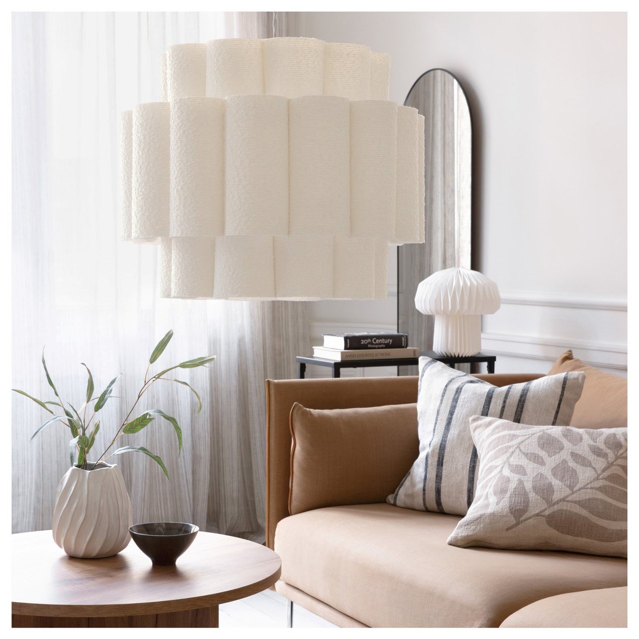 Vardagsrum med soffa, soffbord och dekorativa lampor i ett ljust inrett rum.