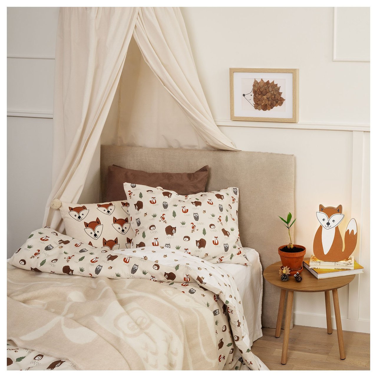 Kinderbett mit Bettwäsche mit Tiermotiven.