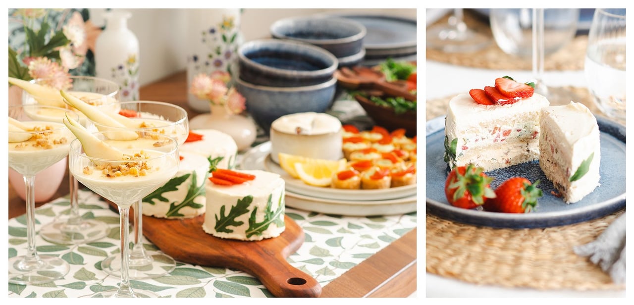 Gedeckter Tisch mit Desserts, Keksen und Kuchen, verziert mit Erdbeeren in sommerlicher Umgebung.