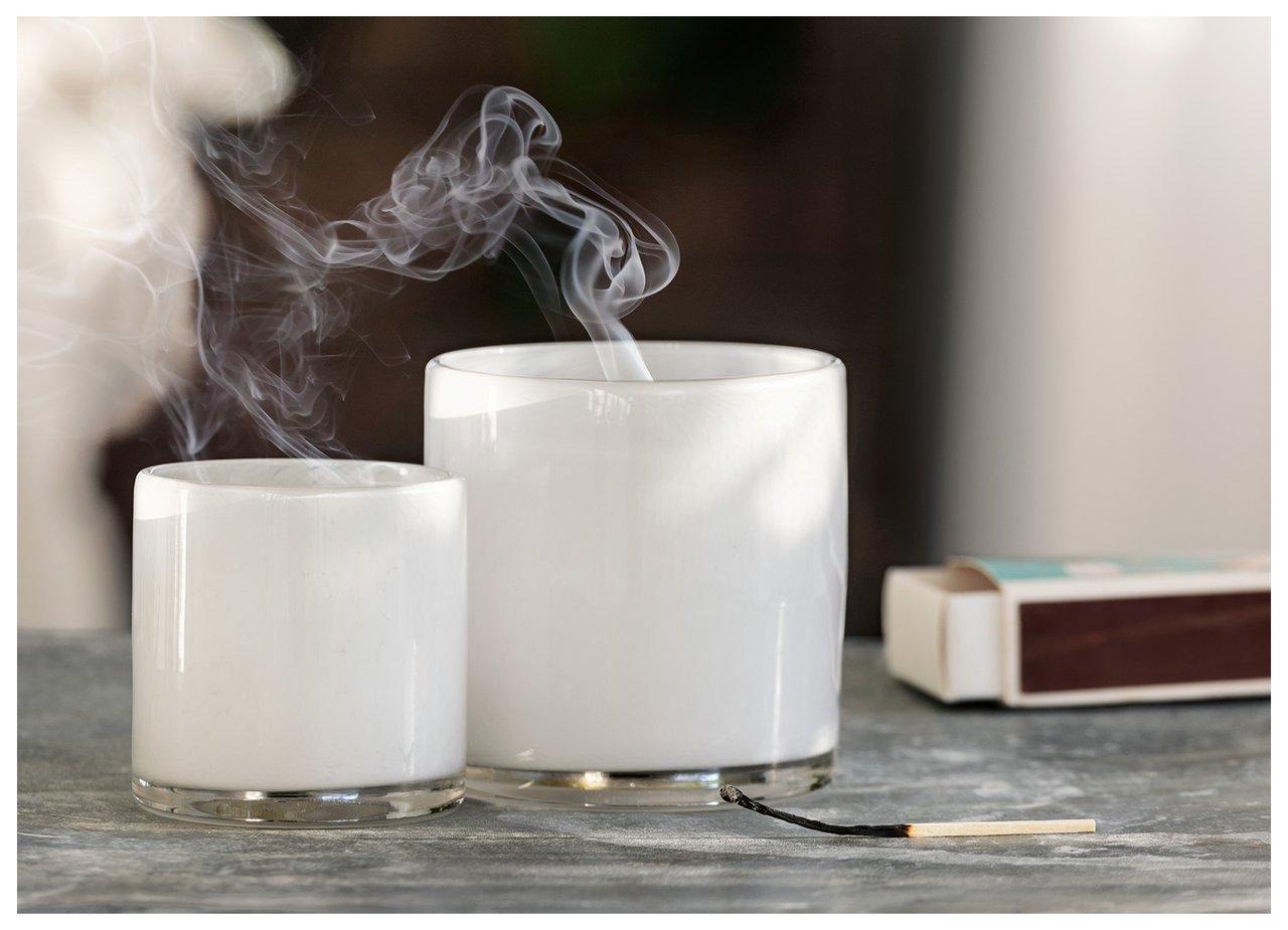 Zwei Glaslaternen, aus denen Rauch aufsteigt, nachdem die Kerzen gelöscht wurden, Streichholz und Streichholzschachtel liegen daneben.