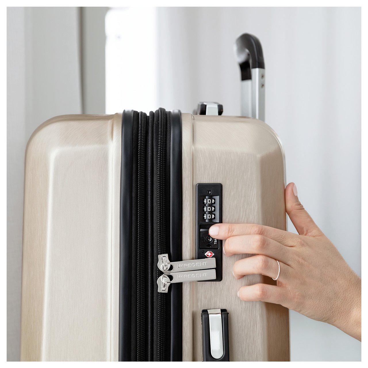 Nahaufnahme einer Hand, die ein Zahlenschloss an einem Hartschalenkoffer einstellt.