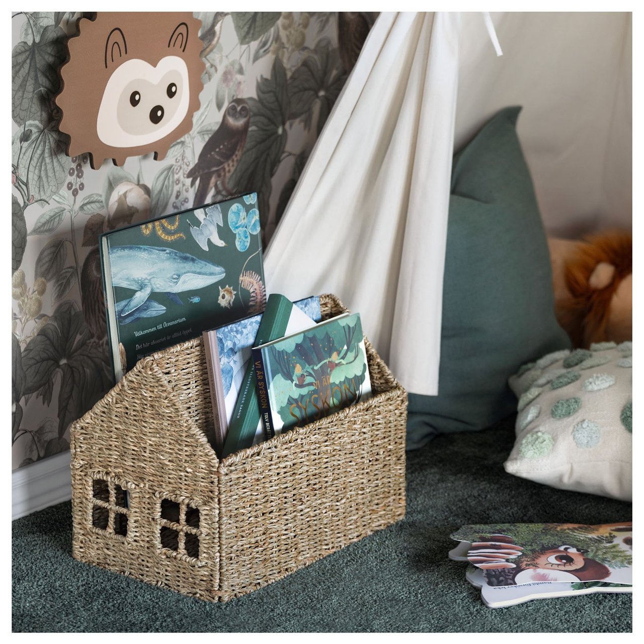 Barnerom med en oppbevaringskurv for bøker formet som et hus.