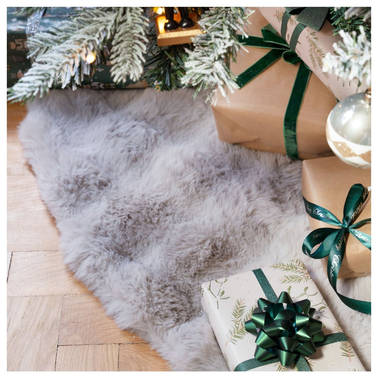 Flauschige graue Baumdecke mit Geschenken unter dem Baum.