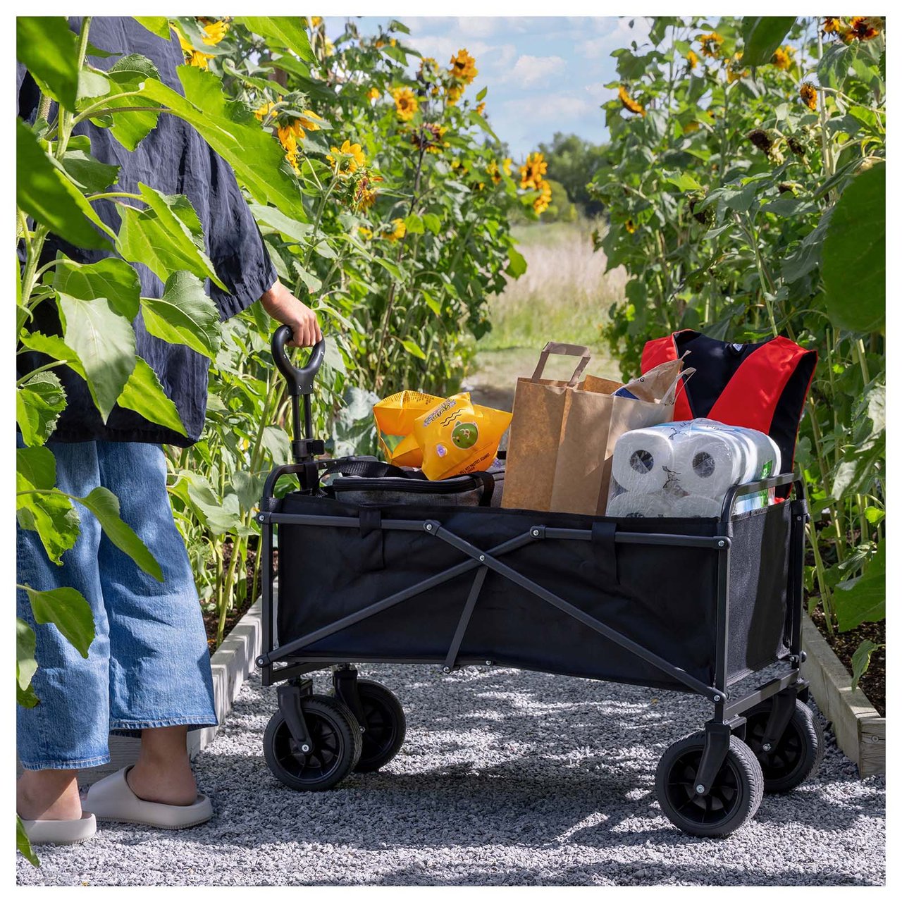 Harmonisk piknikutstyr i grønne toner med mønstret teppe, matchende kjølebag, sammenleggbar vogn og matbokser.